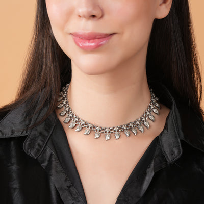 Woman wearing a silver choker necklace with a black shirt