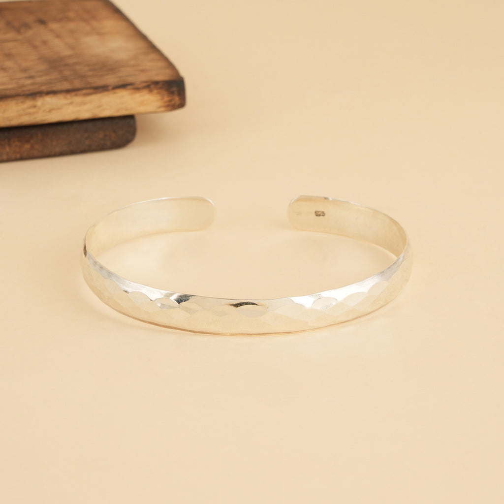 Silver open bracelet on a beige surface with 92.5 hallmarking