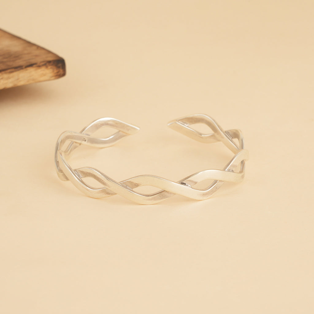 Silver open kada bracelet on a beige background