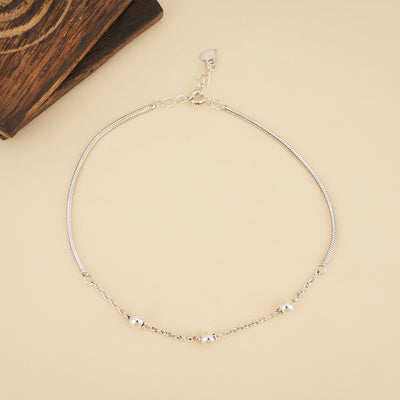 925 sterling silver heart charm anklet with delicate chain details and dangling heart charms on a neutral background.