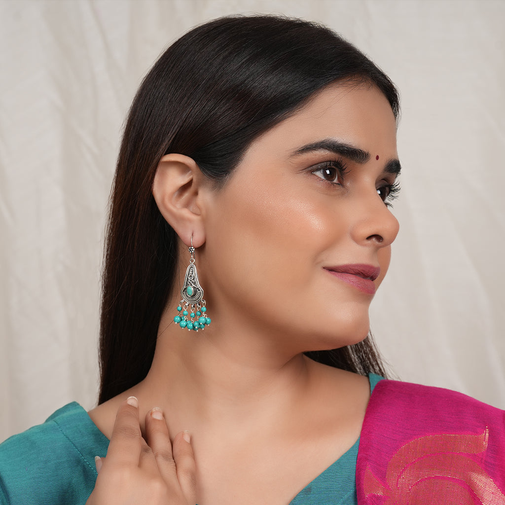 Model Wearing Oxidised silver earrings with intricate detailing and hanging turquoise beads
